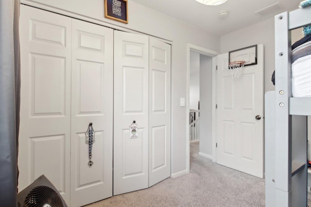 unfurnished bedroom featuring light carpet and a closet