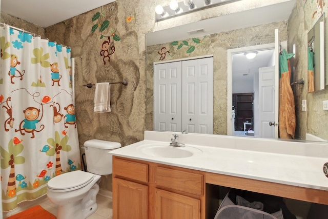 bathroom featuring tile patterned floors, vanity, toilet, and walk in shower