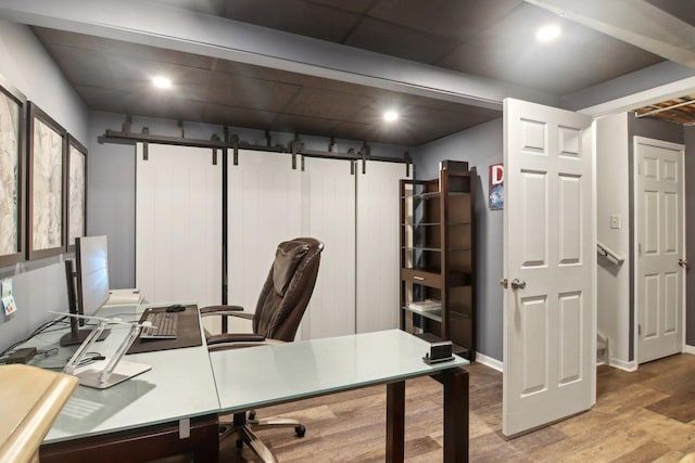 home office featuring hardwood / wood-style floors and a barn door