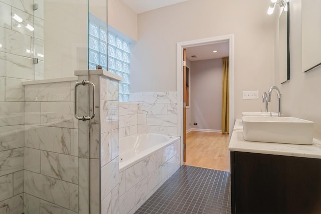 bathroom featuring hardwood / wood-style flooring, vanity, and plus walk in shower