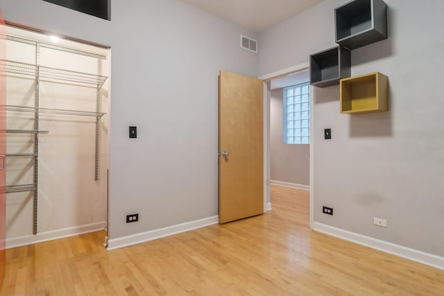 unfurnished bedroom with light wood-type flooring and a closet