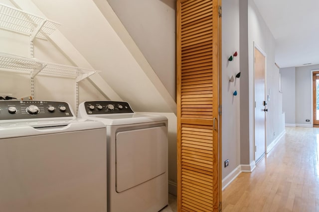 laundry area with light hardwood / wood-style floors and separate washer and dryer