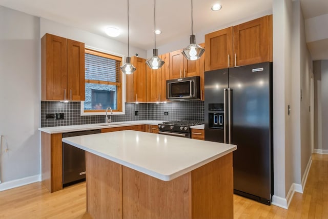 kitchen featuring high quality appliances, sink, decorative backsplash, decorative light fixtures, and a kitchen island