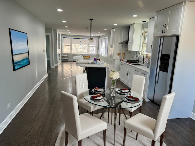 dining space featuring sink and dark wood-type flooring