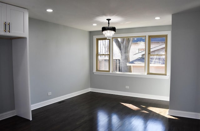 unfurnished dining area featuring dark wood-type flooring and an inviting chandelier