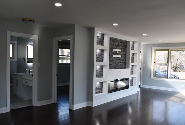 corridor with dark hardwood / wood-style floors, built in features, and sink