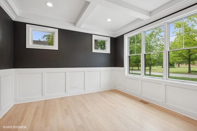 spare room with beam ceiling, light wood-type flooring, and coffered ceiling