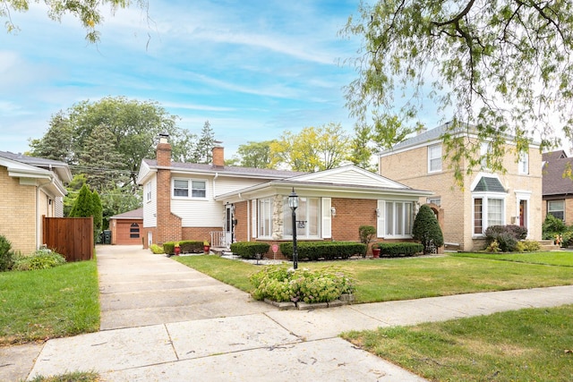 view of front of property with an outbuilding, a front lawn, and a garage