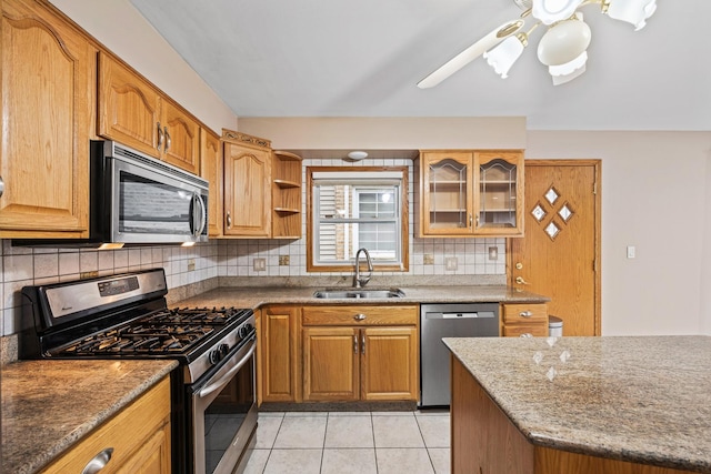 kitchen featuring stone counters, sink, stainless steel appliances, backsplash, and light tile patterned flooring