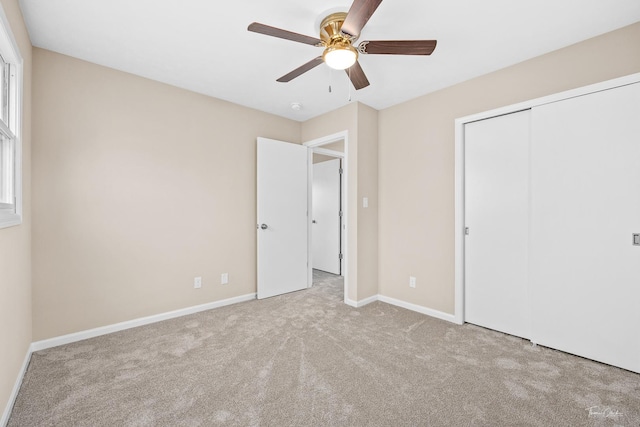 unfurnished bedroom featuring ceiling fan, a closet, and light carpet