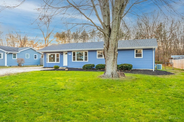 ranch-style home featuring cooling unit and a front lawn