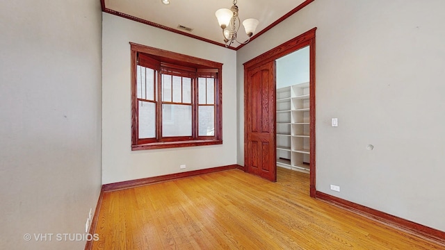 unfurnished room with ornamental molding, light hardwood / wood-style floors, and a chandelier