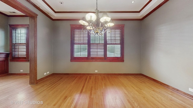 empty room with ornamental molding, a notable chandelier, light hardwood / wood-style floors, and a healthy amount of sunlight