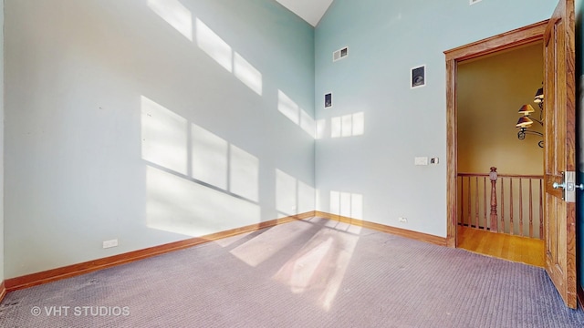 unfurnished room featuring high vaulted ceiling and carpet flooring