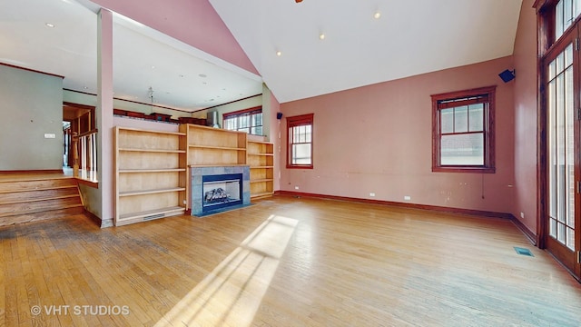 unfurnished living room with high vaulted ceiling and wood-type flooring