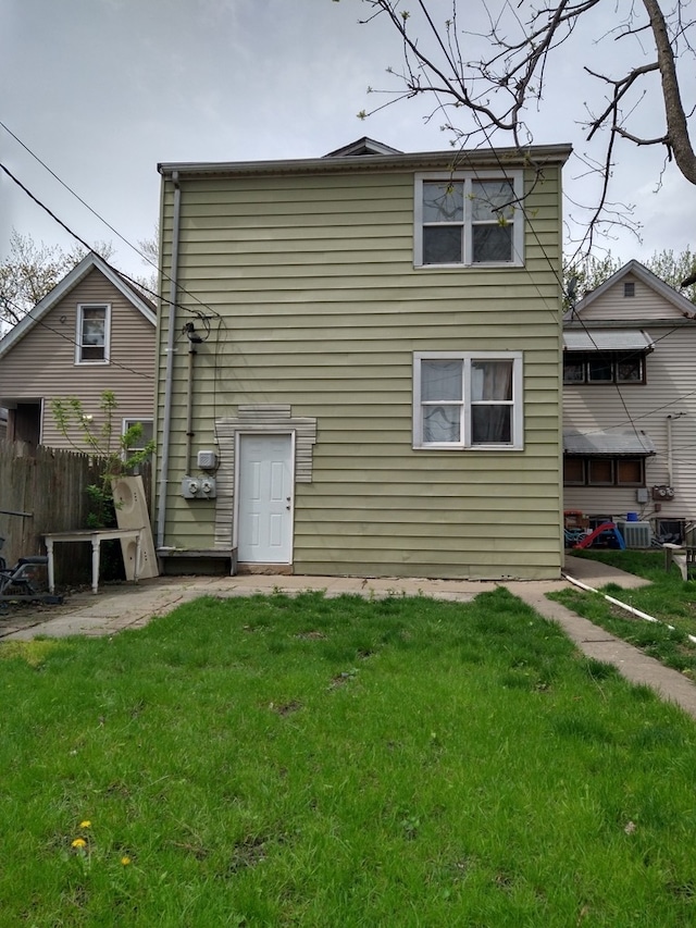 rear view of property with a lawn