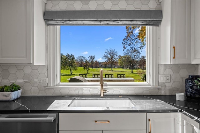 kitchen featuring white cabinetry, sink, dishwasher, and a wealth of natural light