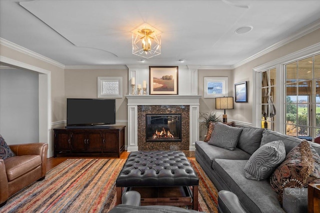 living room featuring a fireplace, hardwood / wood-style floors, crown molding, and a wealth of natural light