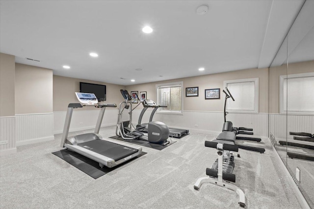 workout room featuring light carpet