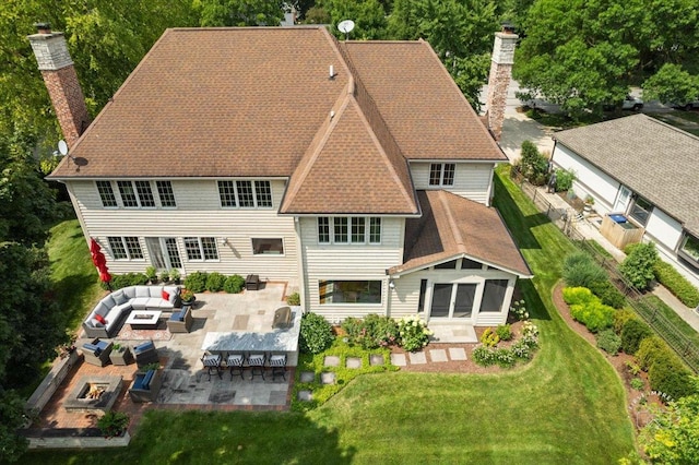 rear view of property with outdoor lounge area, a patio, a yard, and an outdoor bar