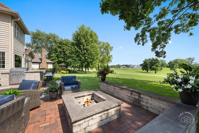 view of patio featuring grilling area, exterior kitchen, and an outdoor fire pit