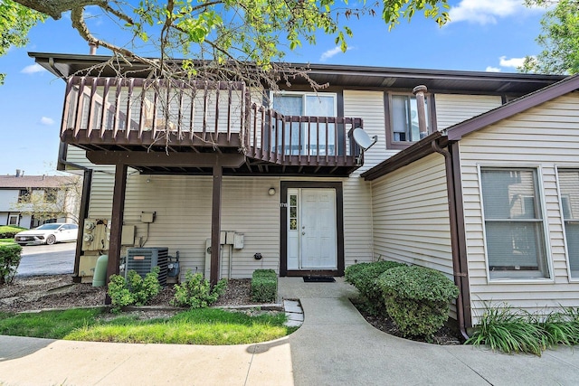 view of front of property featuring a balcony, a deck, and cooling unit