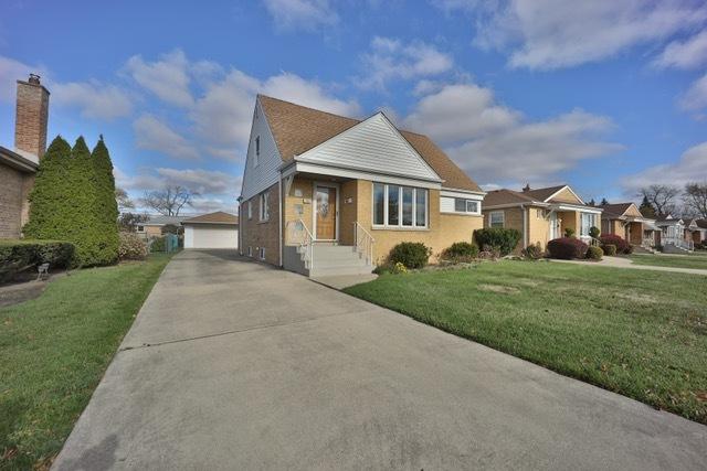 view of front facade with an outbuilding, a front yard, and a garage