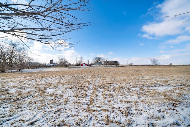 snowy yard with a rural view