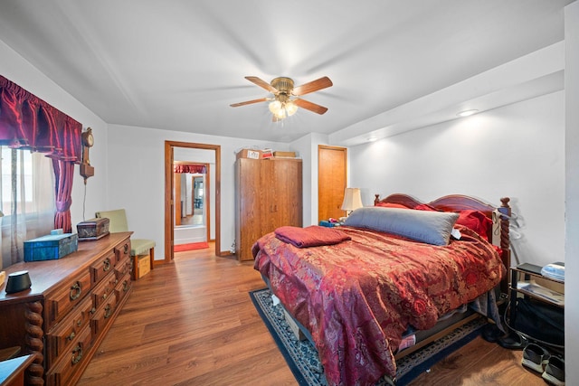 bedroom with connected bathroom, hardwood / wood-style flooring, and ceiling fan