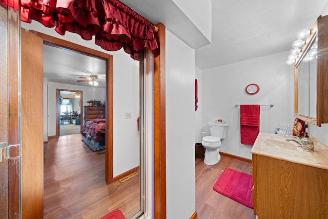 bathroom featuring hardwood / wood-style floors, vanity, ceiling fan, and toilet