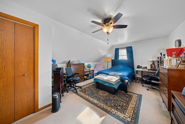 carpeted bedroom featuring ceiling fan, lofted ceiling, and a closet