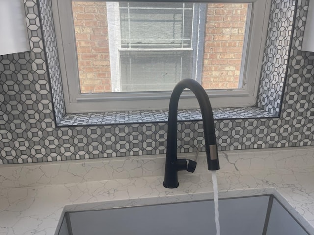 interior details featuring light stone countertops and sink