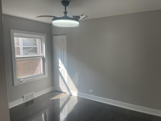 empty room featuring dark hardwood / wood-style flooring and ceiling fan