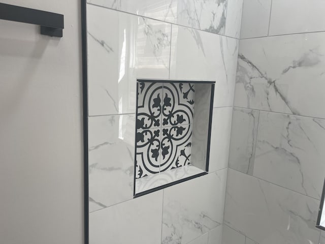 interior details featuring tiled shower