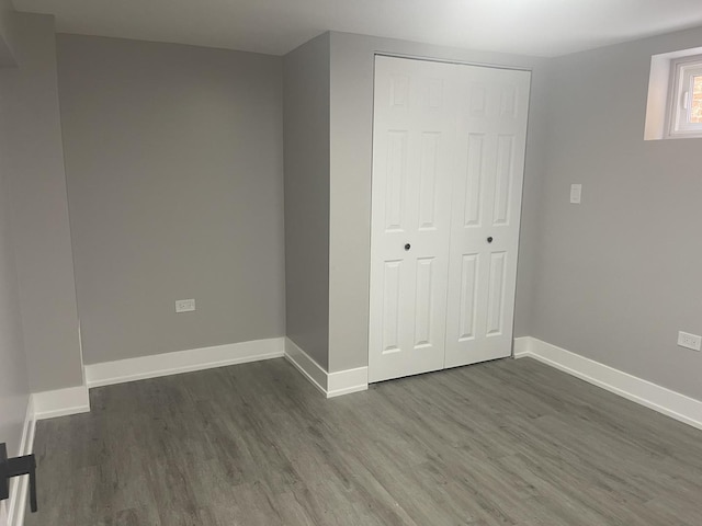 unfurnished bedroom with dark hardwood / wood-style floors and a closet