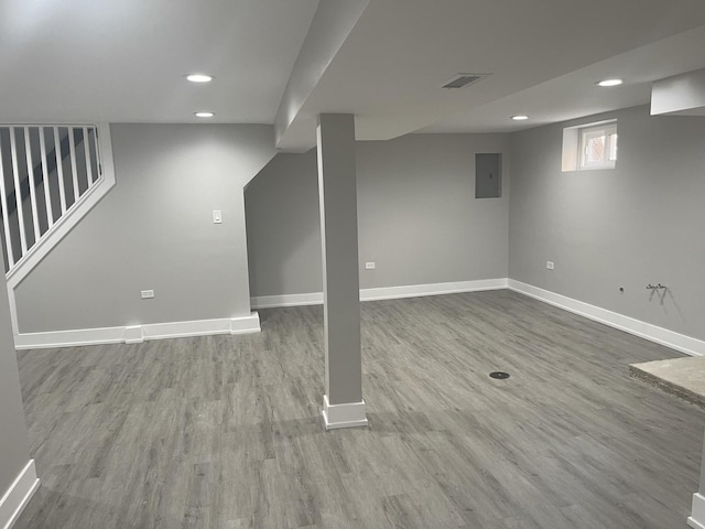 basement with electric panel and hardwood / wood-style floors