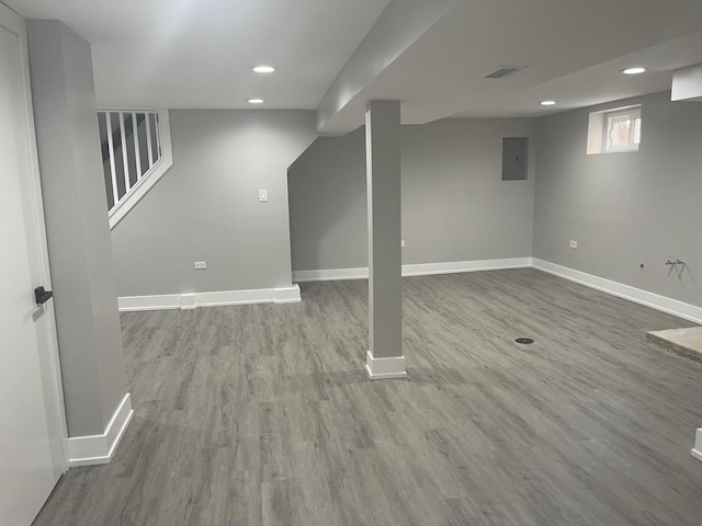 basement with electric panel and hardwood / wood-style floors