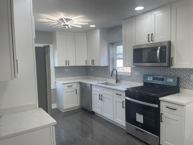 kitchen featuring light stone countertops, white cabinetry, sink, and appliances with stainless steel finishes