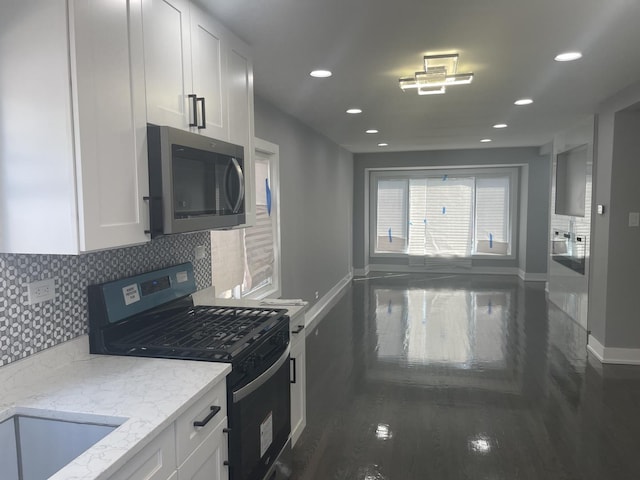 kitchen with white cabinetry, black stove, light stone countertops, tasteful backsplash, and dark hardwood / wood-style flooring