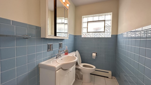 bathroom featuring tile patterned floors, vanity, a baseboard radiator, and tile walls