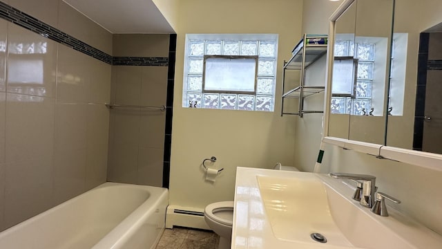 full bathroom with vanity, tiled shower / bath, a baseboard radiator, and toilet