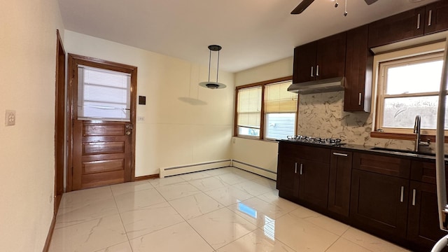 kitchen featuring backsplash, a baseboard heating unit, sink, pendant lighting, and plenty of natural light