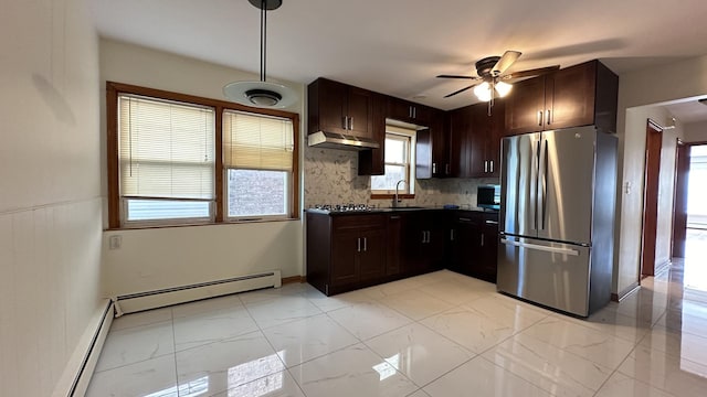 kitchen featuring appliances with stainless steel finishes, tasteful backsplash, ceiling fan, baseboard heating, and sink