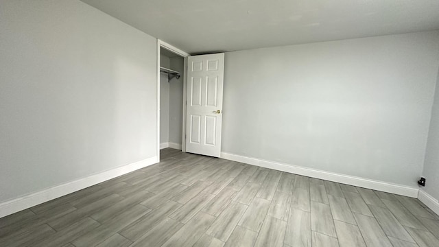 unfurnished bedroom with a closet and light wood-type flooring