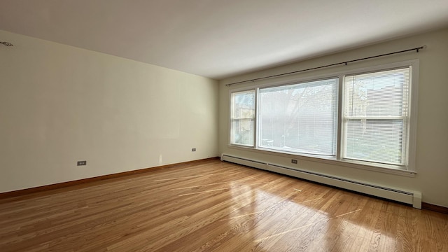 empty room with light hardwood / wood-style floors and baseboard heating