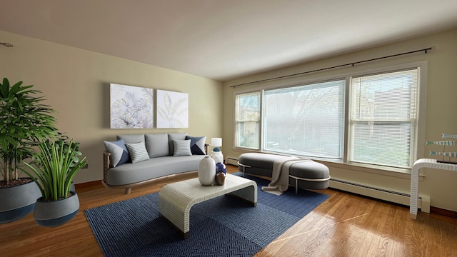 living room featuring a healthy amount of sunlight, a baseboard radiator, and light wood-type flooring