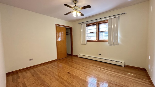 unfurnished bedroom featuring light wood-type flooring, a closet, a baseboard radiator, and ceiling fan