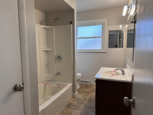 full bathroom with shower / tub combination, vanity, toilet, and tile walls