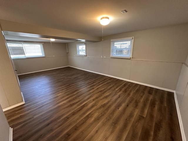 basement with a wealth of natural light and dark wood-type flooring