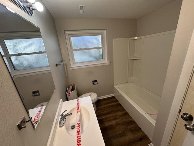 full bathroom featuring hardwood / wood-style floors, vanity, toilet, and shower / tub combination